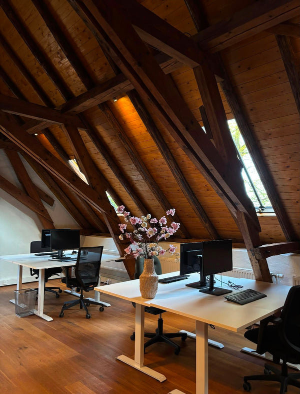 Zijden boeket op een werkplek onder de houten balken van het kantoorpand