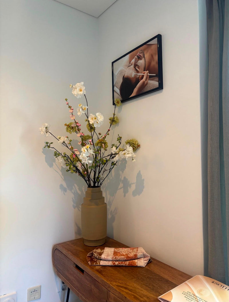 Zijden boeket in vaas op een houten dressoir in een schoonheidssalon